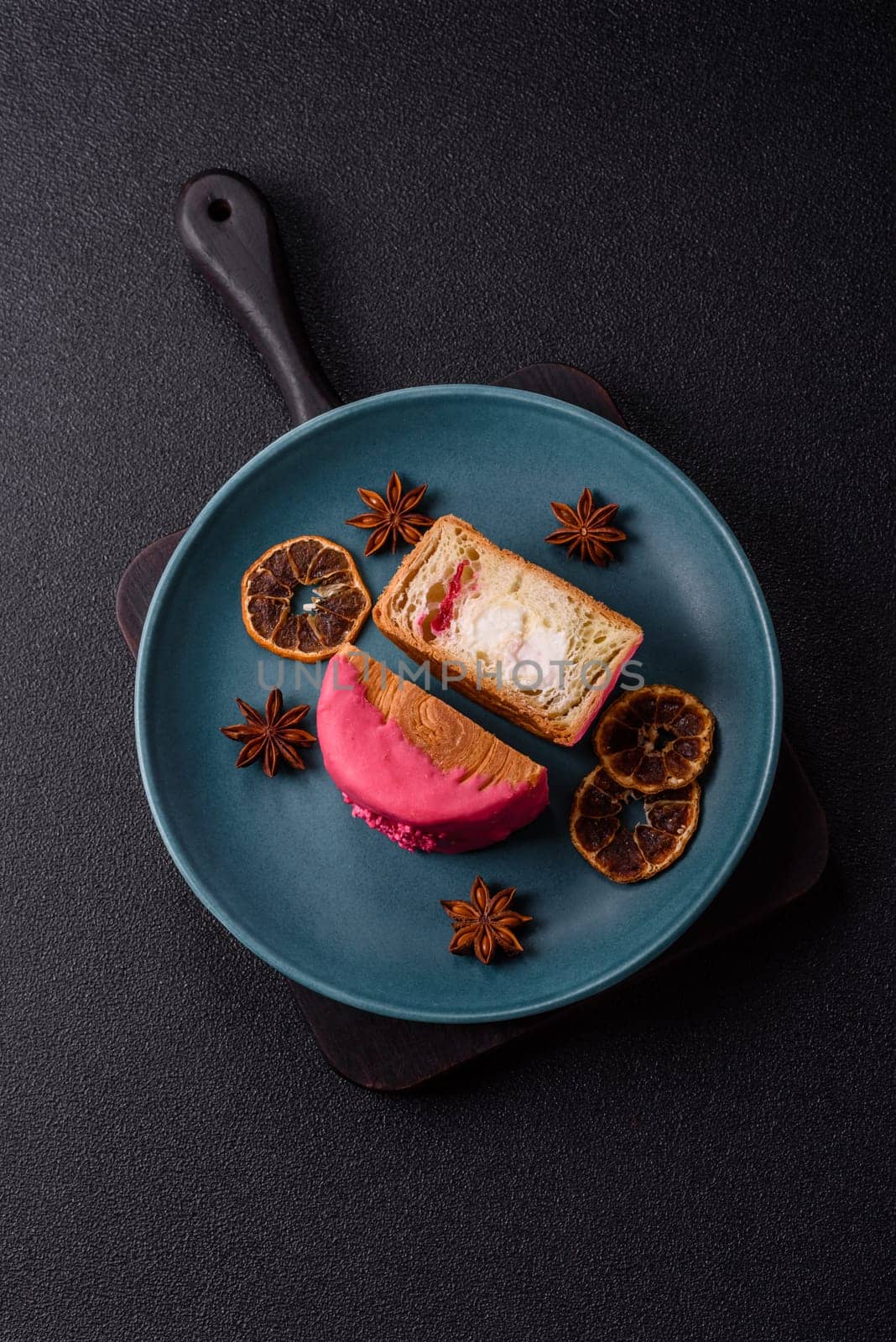 Round sweet New York roll croissant with raspberry cream filling on a dark concrete background