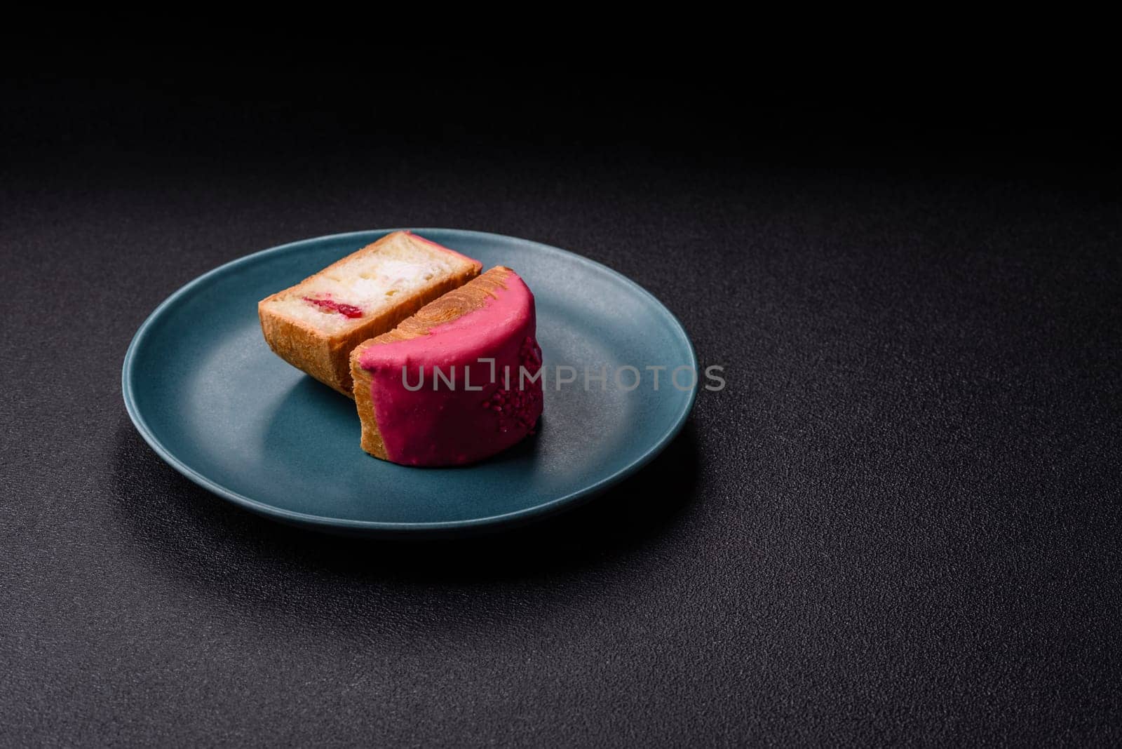 Round sweet New York roll croissant with raspberry cream filling on a dark concrete background