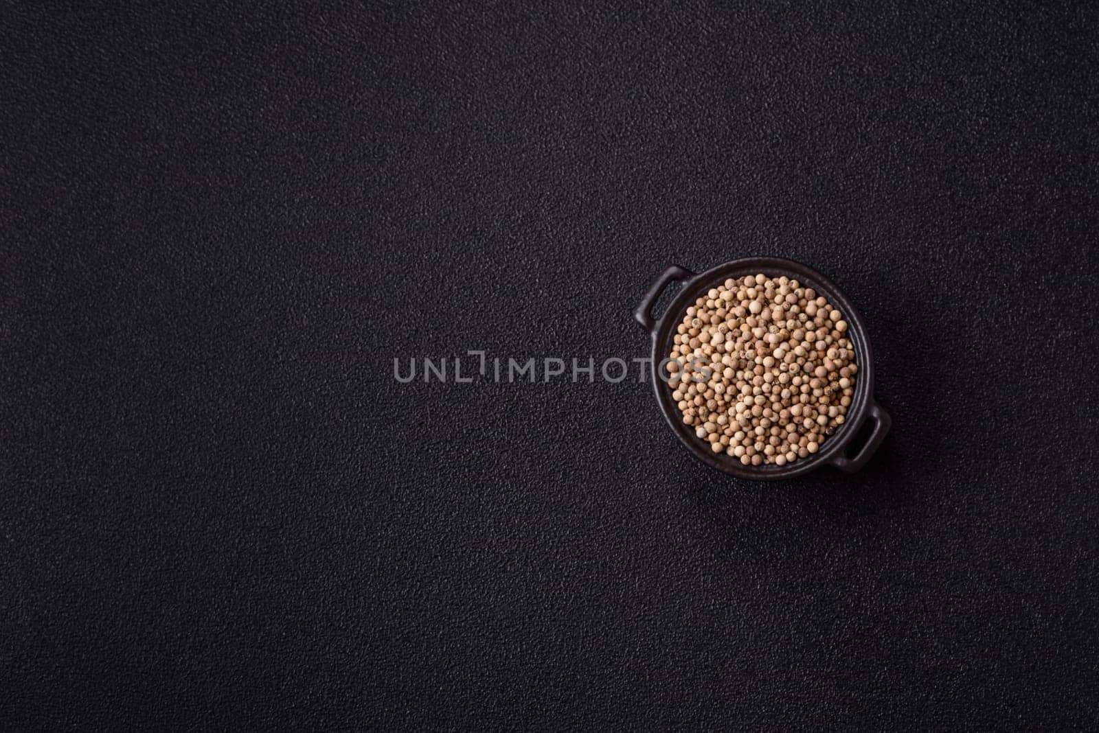 White allspice in a ceramic bowl on a dark concrete background