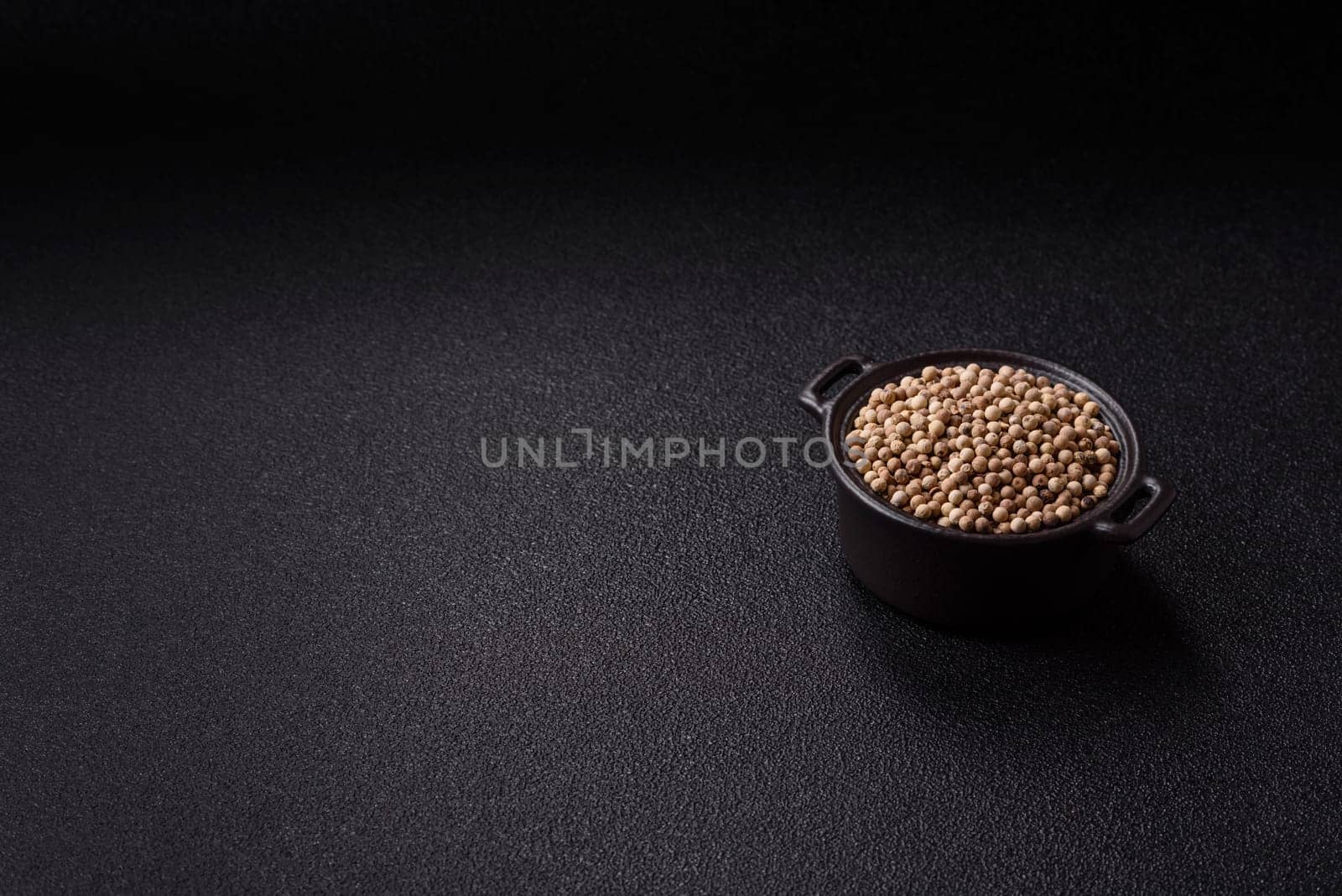 White allspice in a ceramic bowl on a dark concrete background