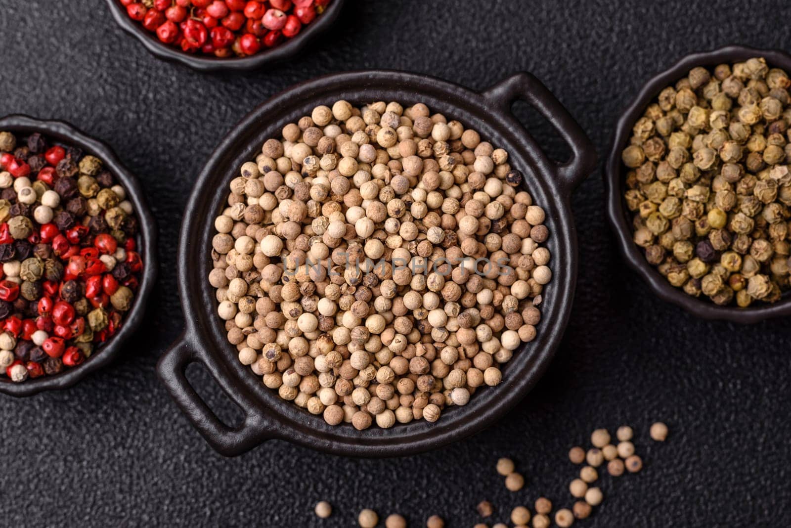 White allspice in a ceramic bowl on a dark concrete background