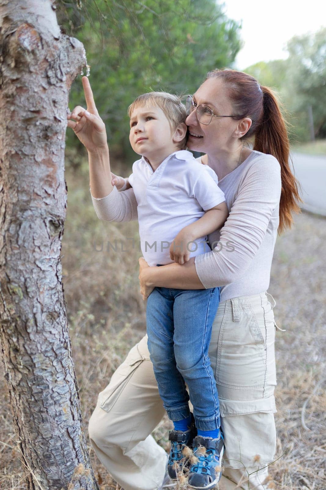 A woman and a child are looking at a tree. Scene is warm and loving