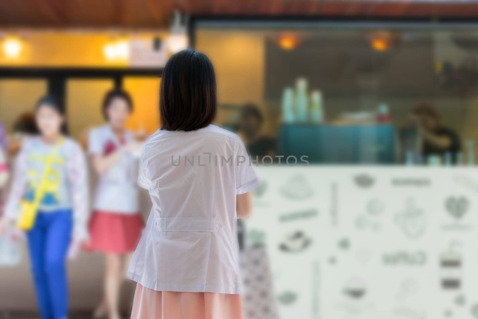 Asian women in white gown about health care professional standing for waiting a coffee at coffee shop in hospital.