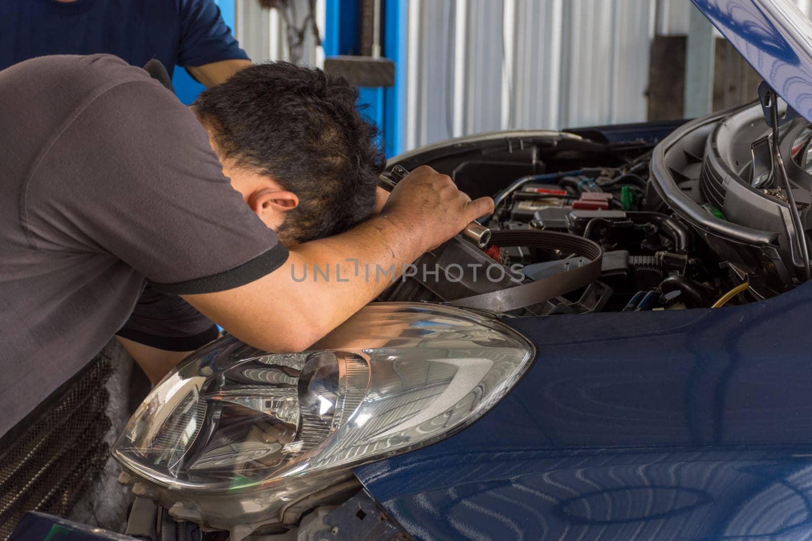 Serviceman checking a car for fix and repair at garage