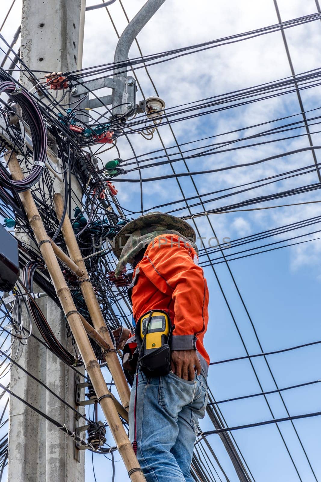 Worker working to install electric line by scaffolding on pickup truck at Bangkok Thailand.