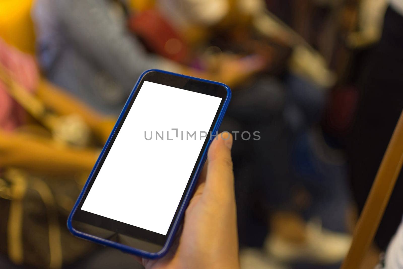 Person hand holding smartphone or mobile phone with white screen using in skytrain for checking