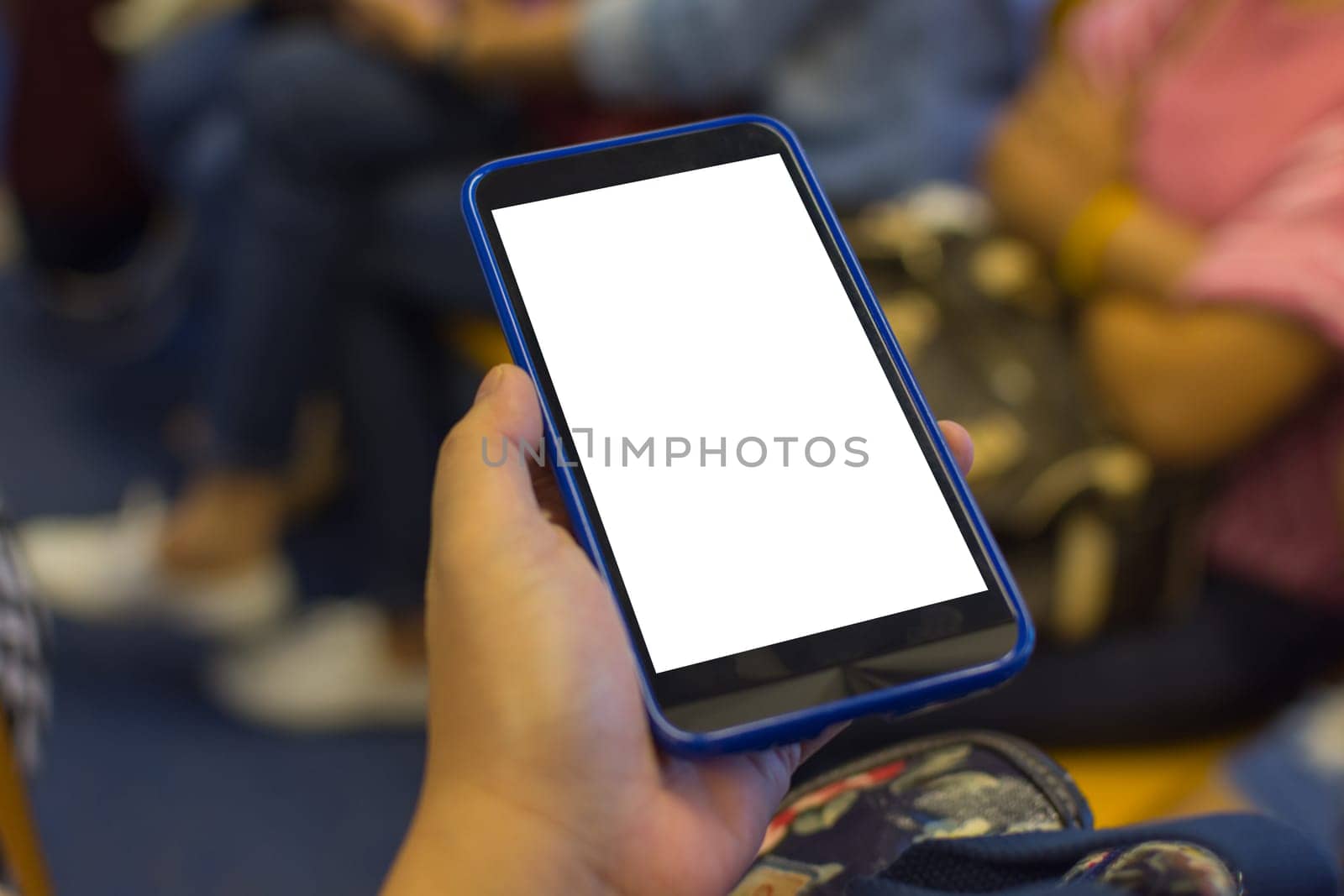 Person hand holding smartphone or mobile phone with white screen using in skytrain for checking