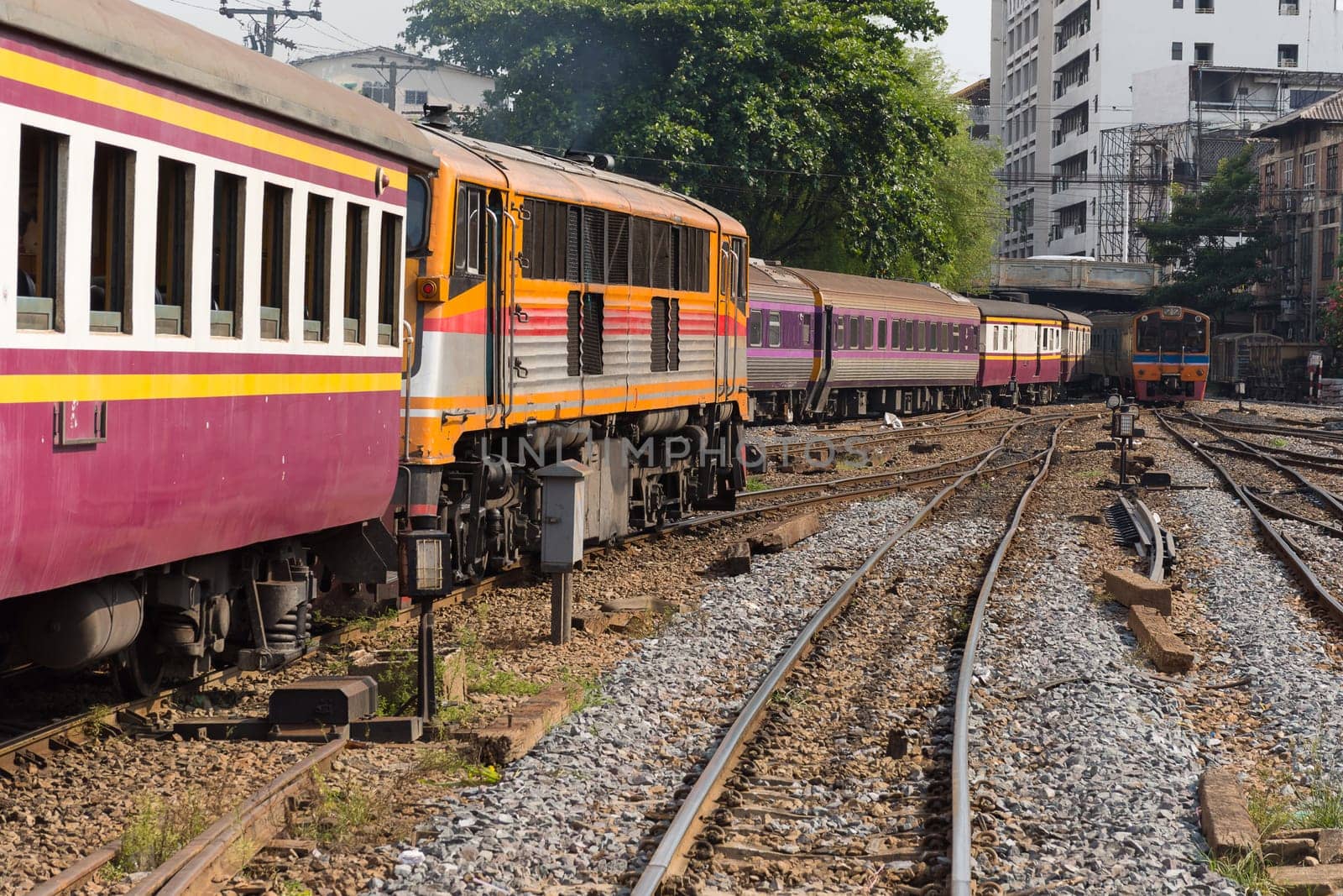 Railway train on the railroad tracks in Bangkok station. Many people in Thailand popular travel by train because it is cheaper.