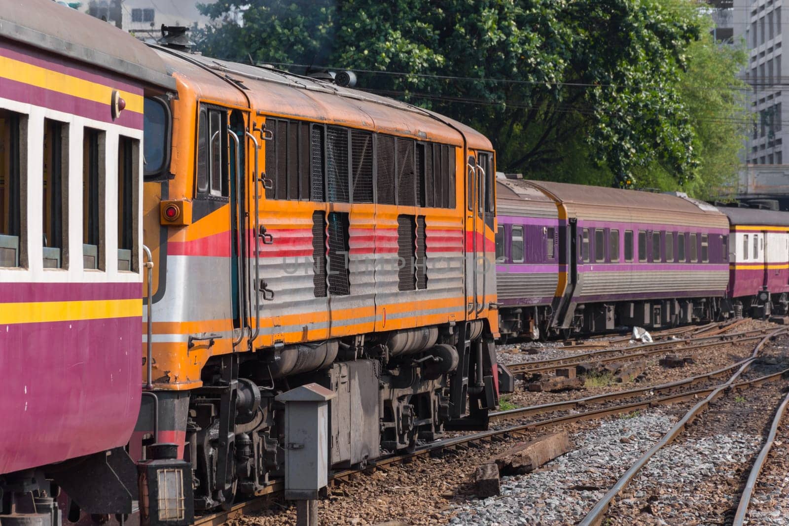 Railway train on the railroad tracks in Bangkok station. Many people in Thailand popular travel by train because it is cheaper.