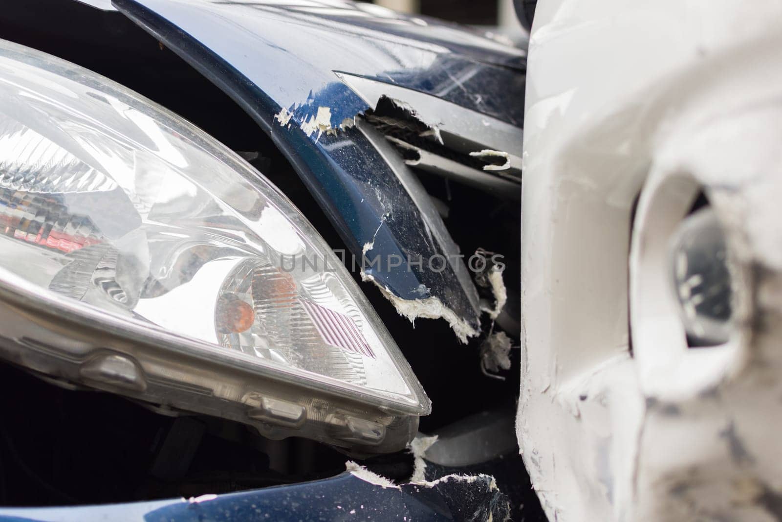 Car crash from car accident on the road in a city between saloon versus pickup wait insurance.