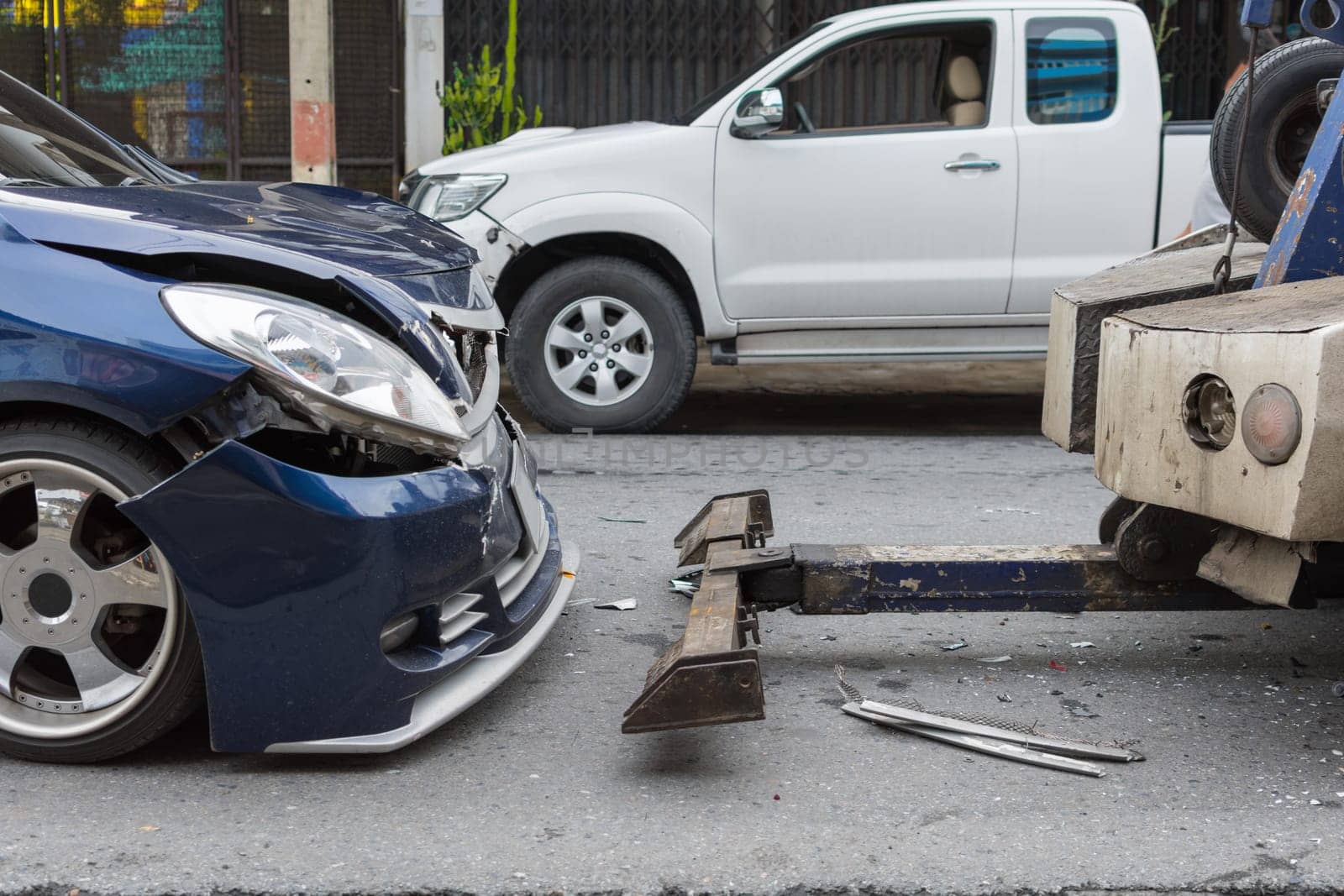 Car crash from car accident on the road in a city between saloon versus pickup wait insurance.
