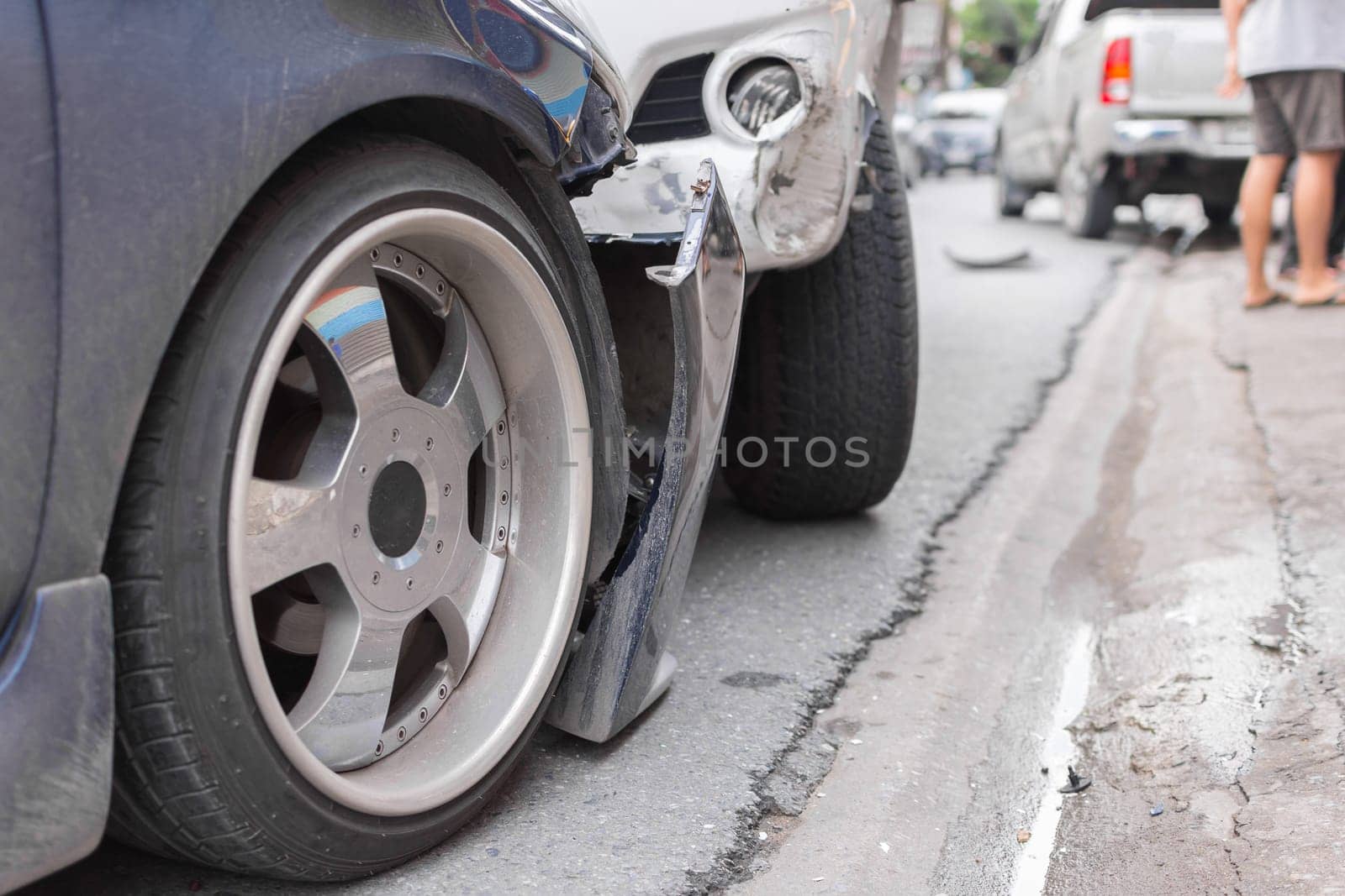 Car crash from car accident on the road in a city between saloon versus pickup wait insurance.
