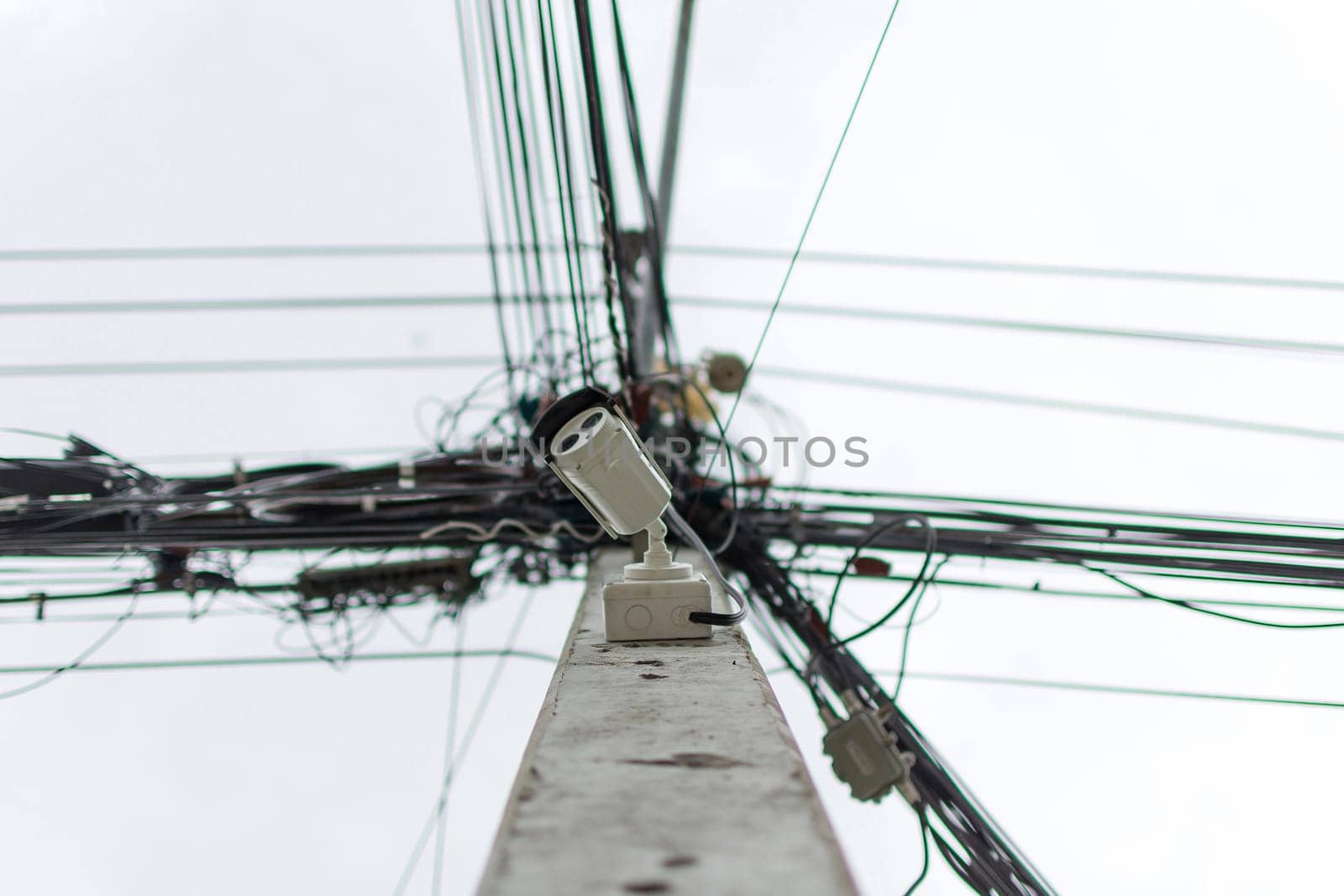 Security camera (CCTV) for safety on pole of electric line and communication with messy line background
