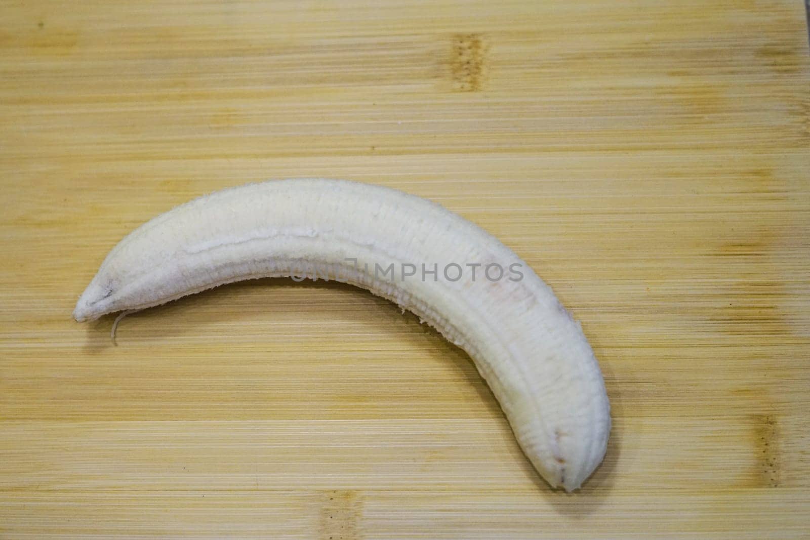 ripe fresh peeled yellow bananas skin on wooden board background fruits healthy snack vitamin eat immune colorful organic . High quality photo