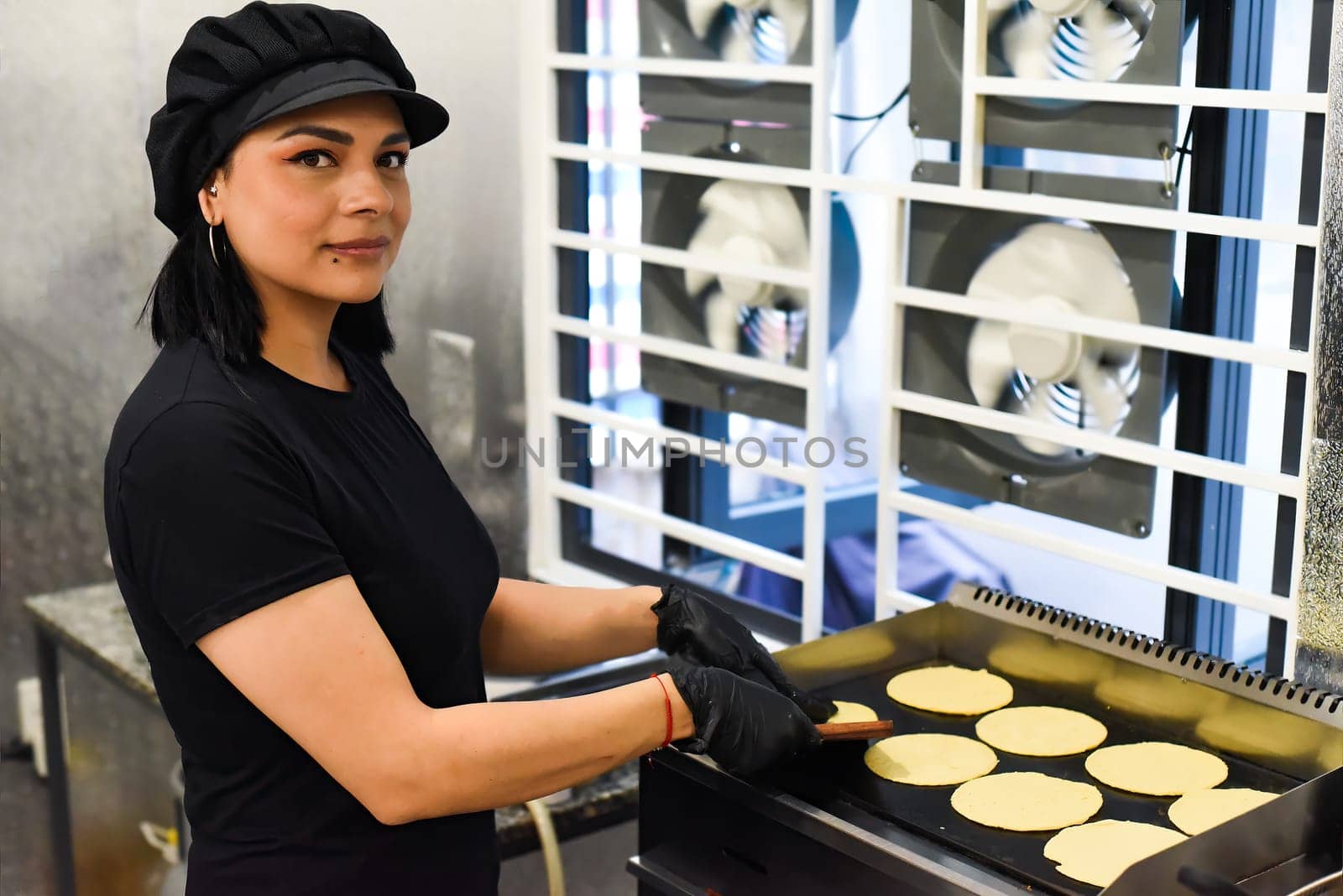 Mexican woman making tacos in a kitchen of a mexican cafe
