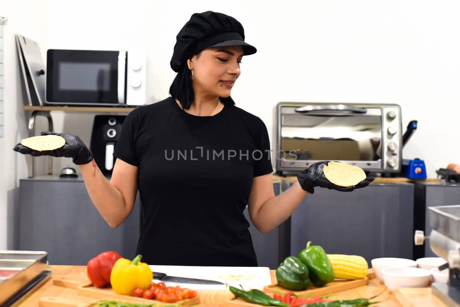 Mexican woman laughing during cooking tacos in the kitchen