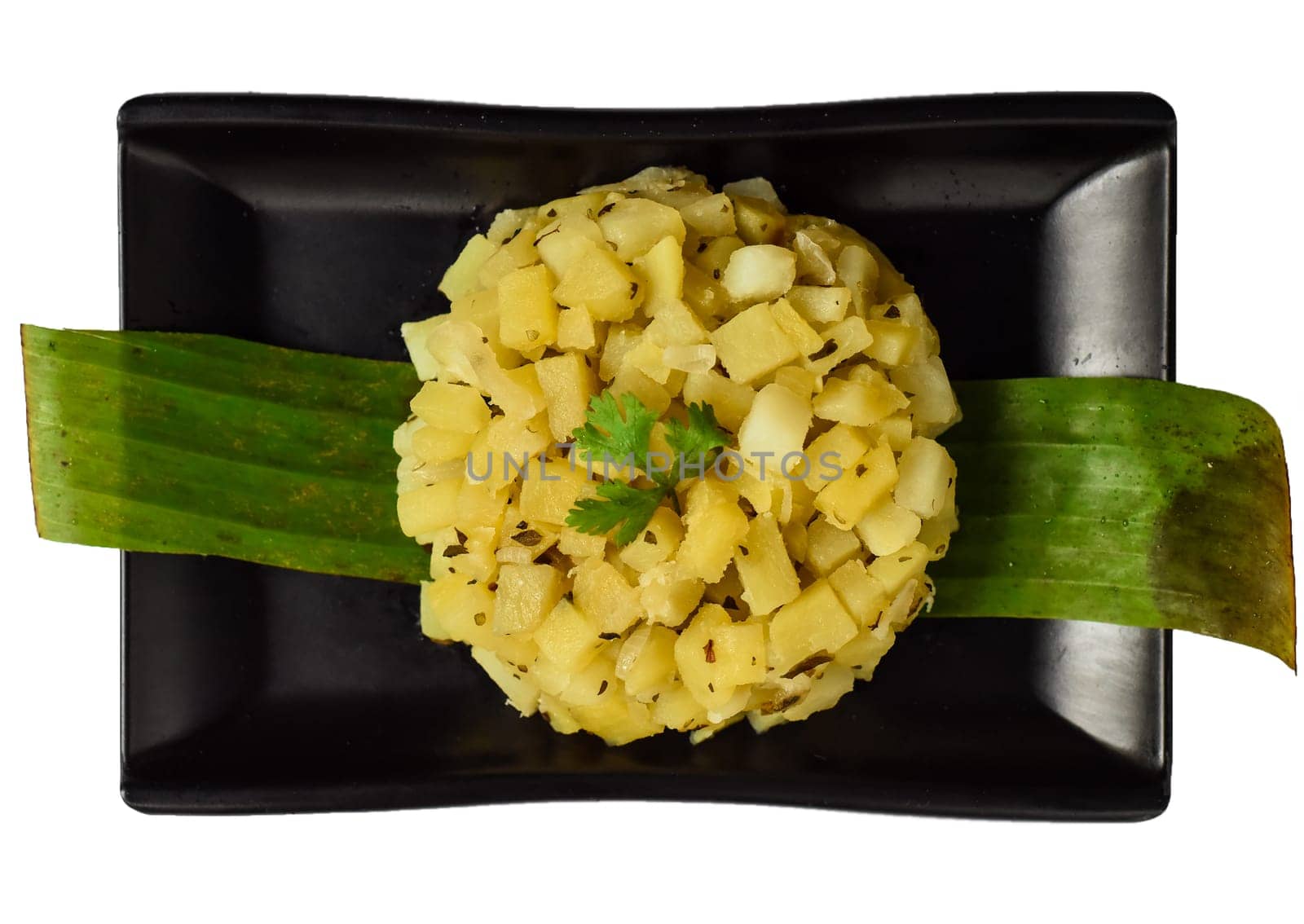 Mexican vegetarian boiled potato with oregano on black plate isolated on white background top view