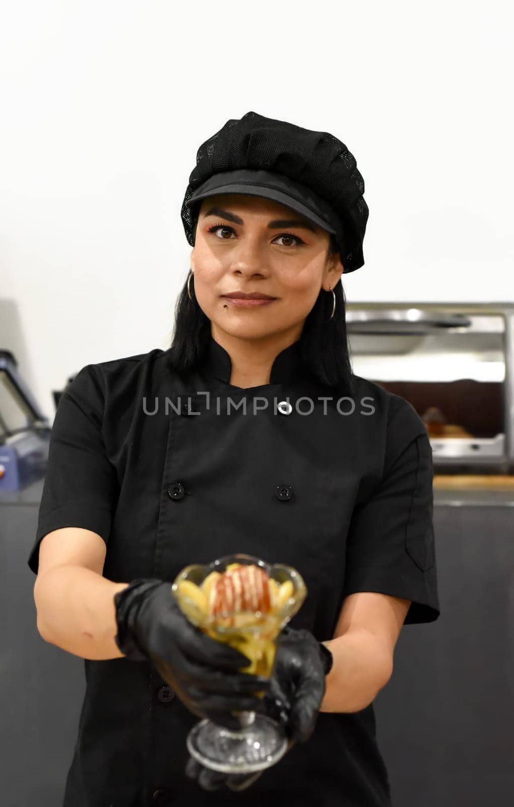 Mexican woman serving santa fe (caramelized banana with whisky) in mexican cafe