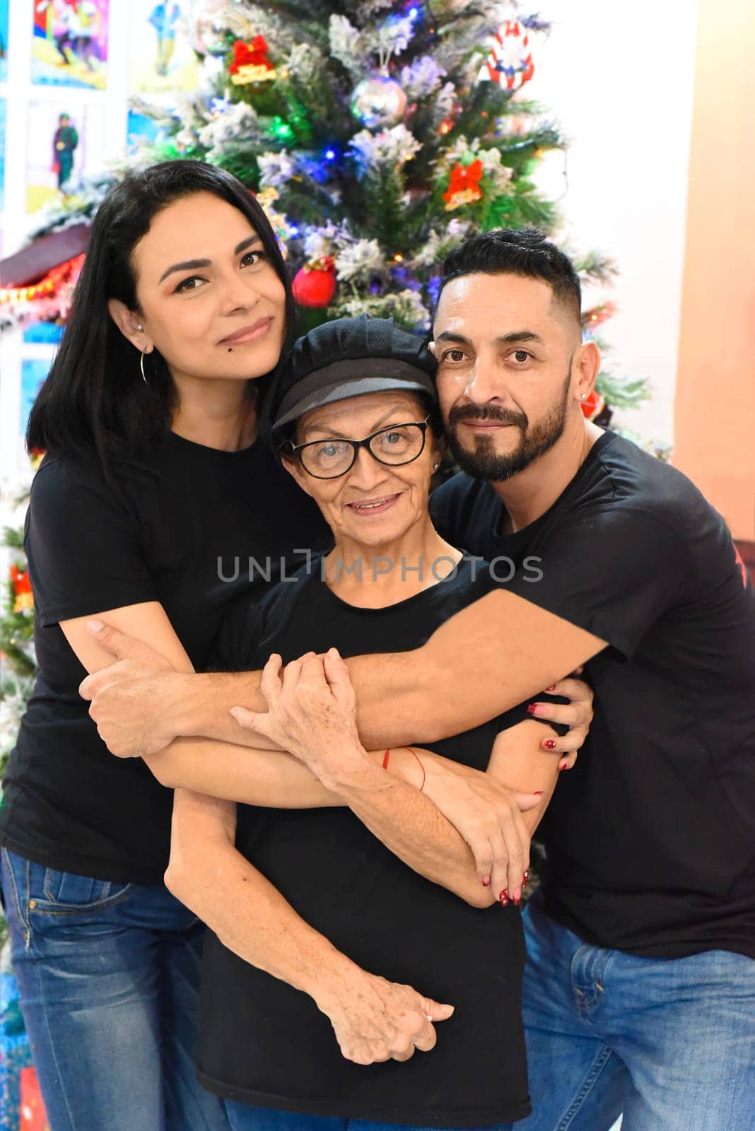 Mexican family standing together against christmas tree