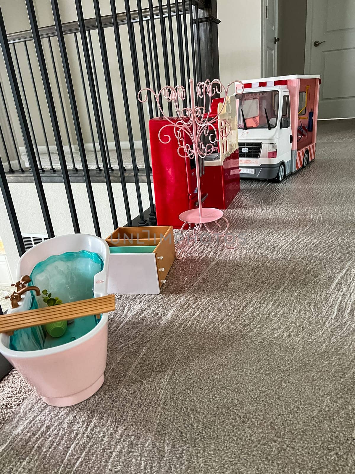 Castle Rock, Colorado, USA-May 13, 2023-A collection of doll furniture and accessories neatly arranged on a carpeted floor The set includes a pink bathtub miniature drawers a coat rack and a toy truck house railing and a closed door in the background suggest a play area or childrens room setting