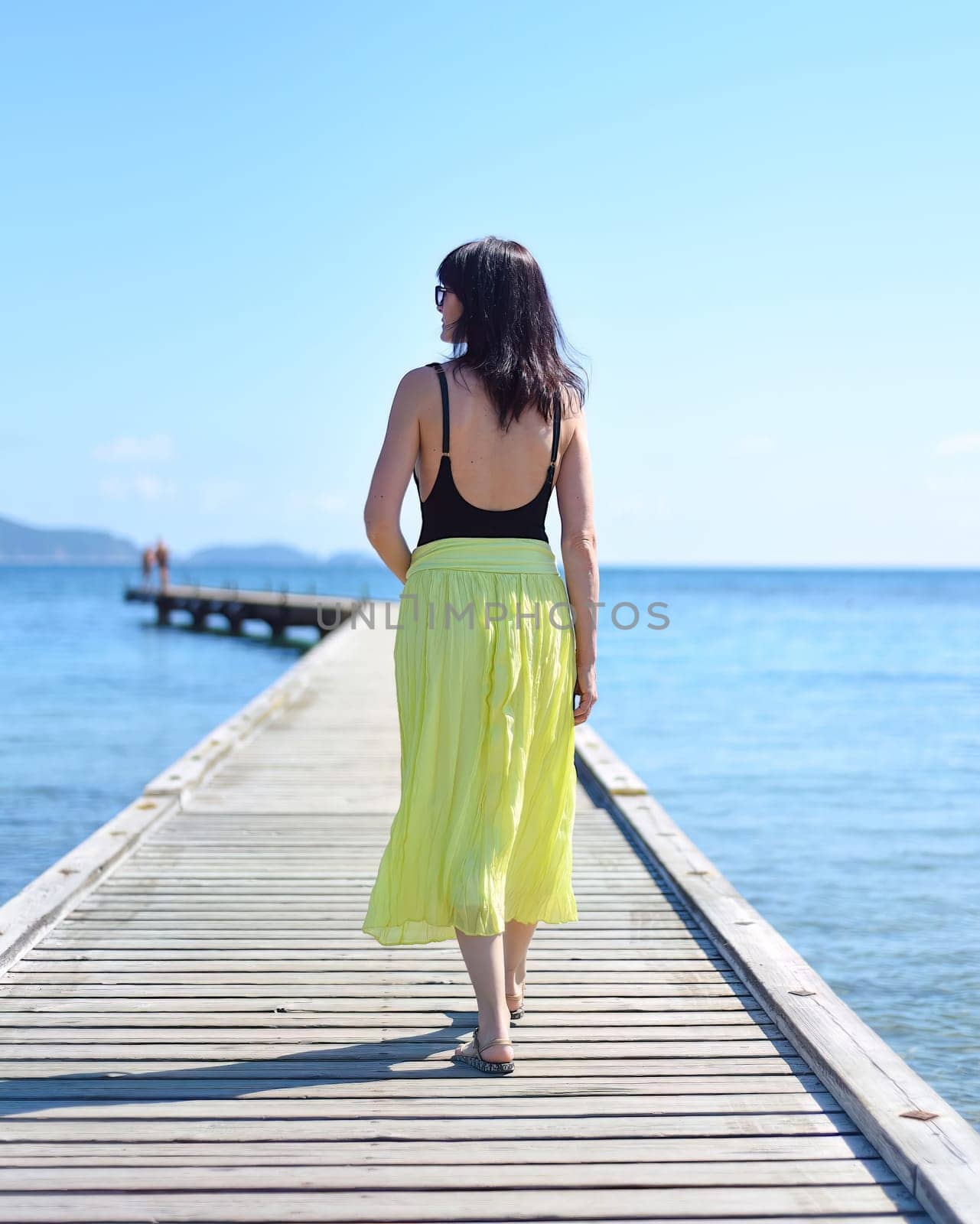 45 years old Russian woman walking on pier against Japanese sea