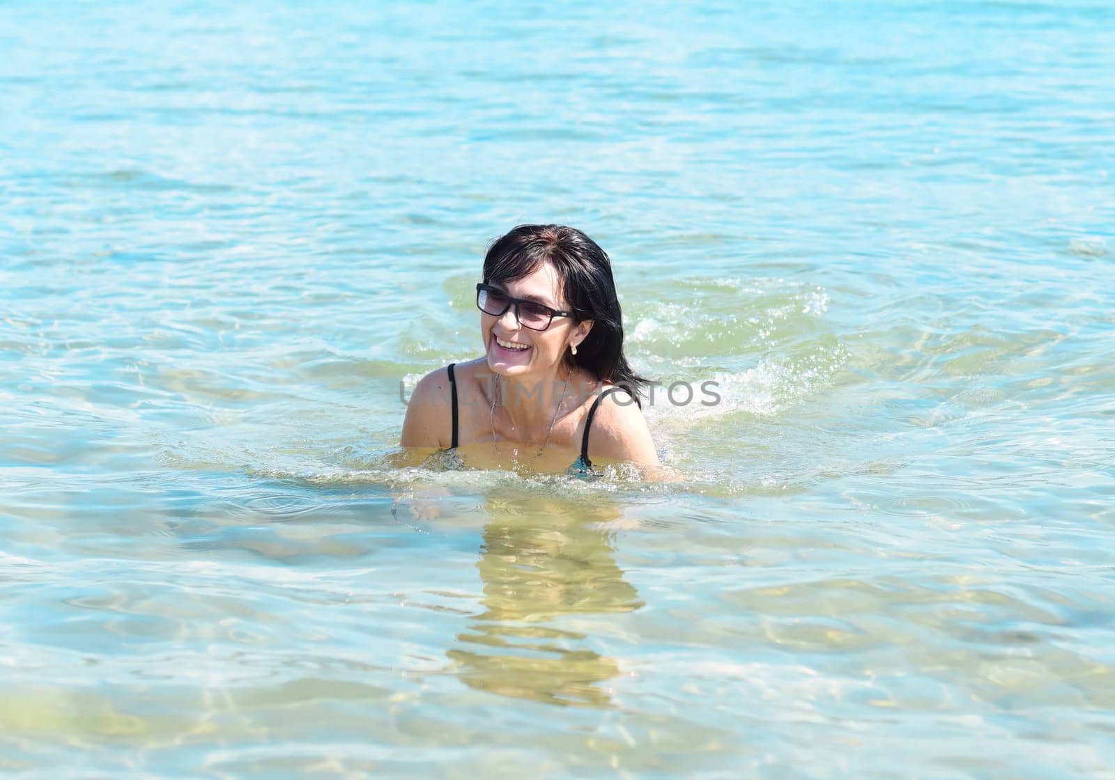 Happy 45 years old Russian woman swimming Japanese sea
