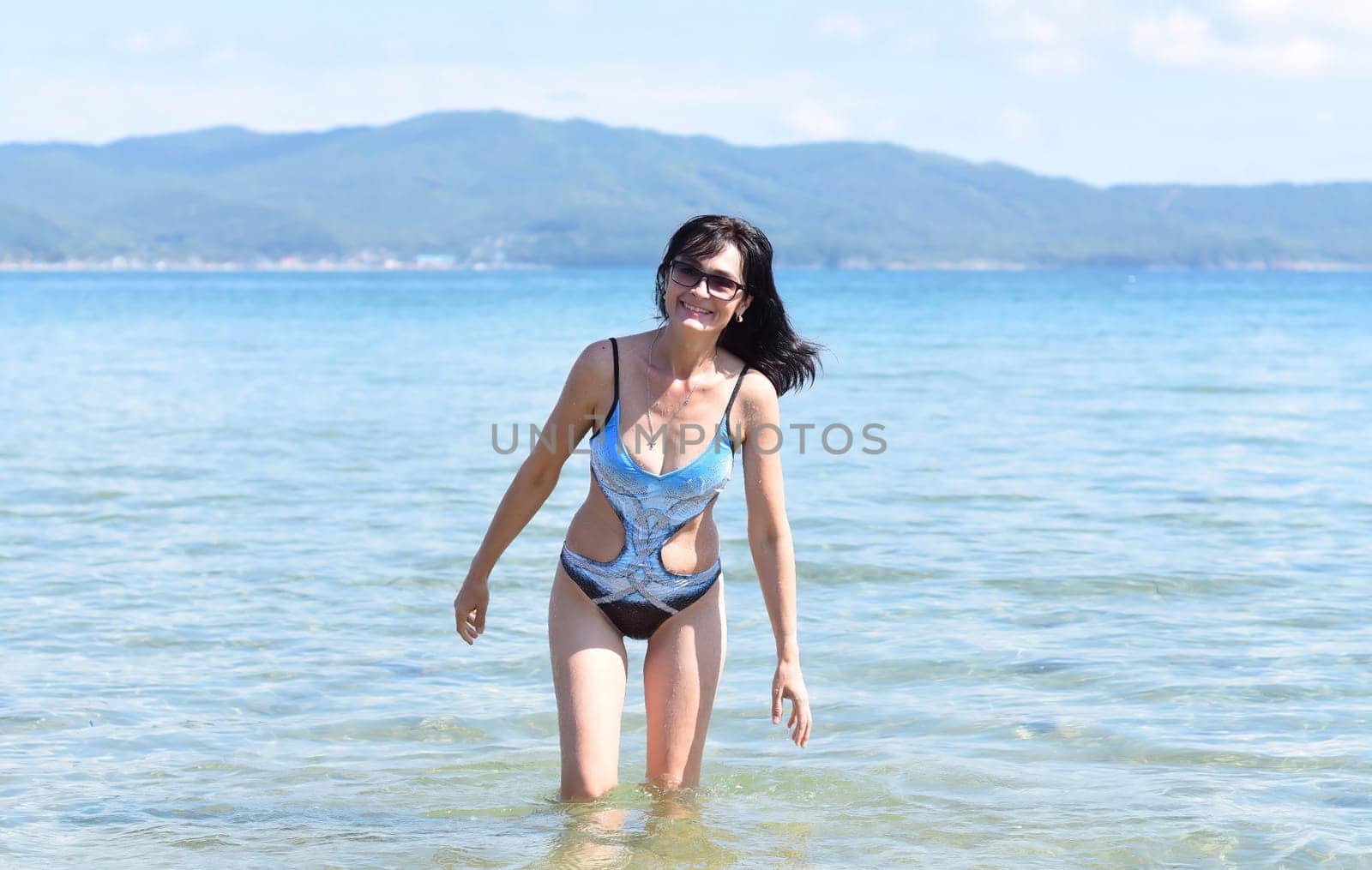 45 years old Russian woman in swimsuit laughing and standing in Japanese sea