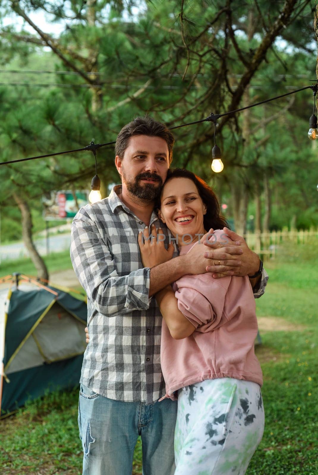 Young married couple feel happy and smile, standing in the forest in the evening