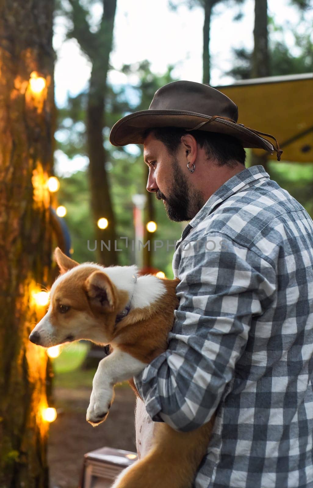 Happy bearded man holding his welsh corgi dog