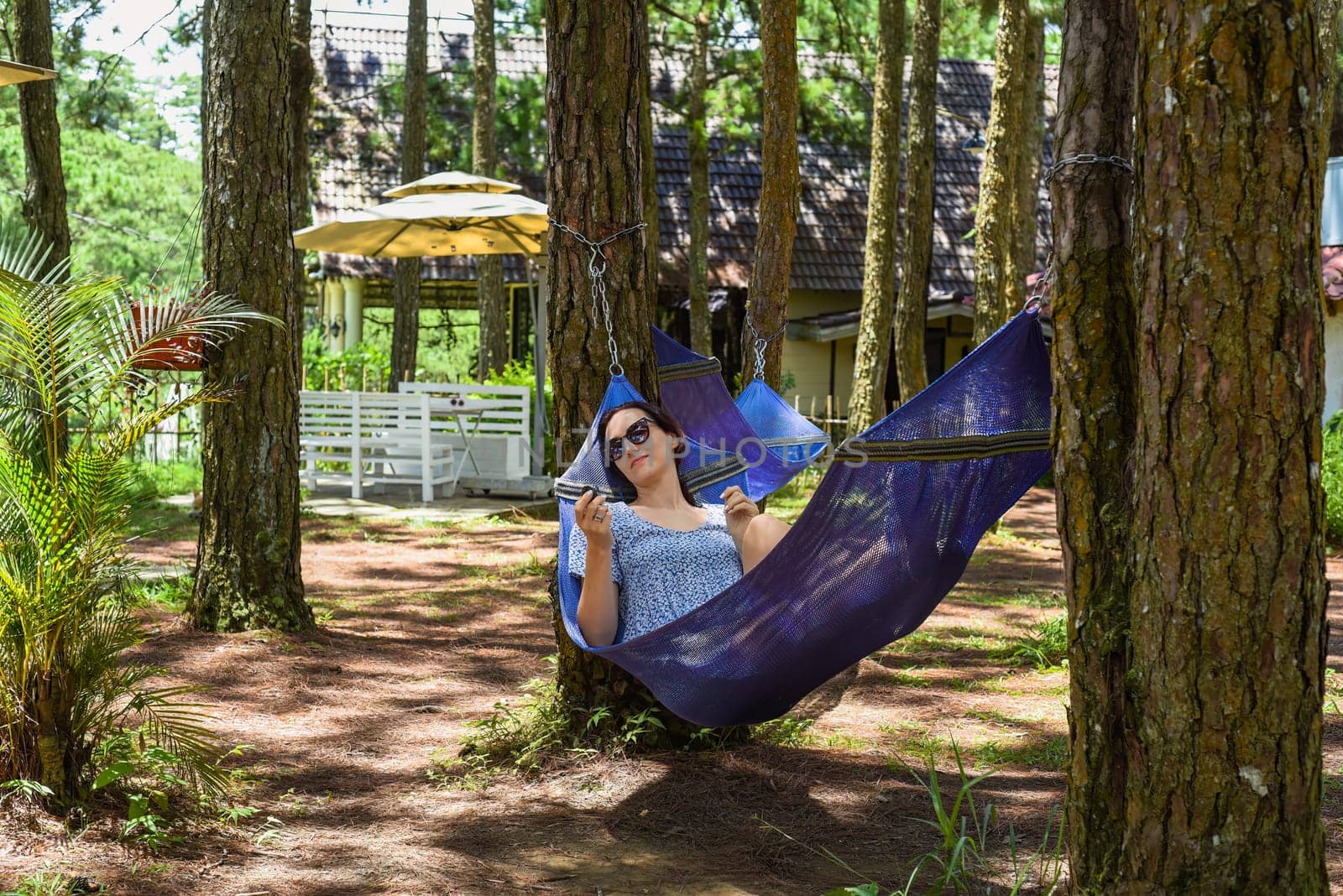 Young brunette woman resting in hammock in forest