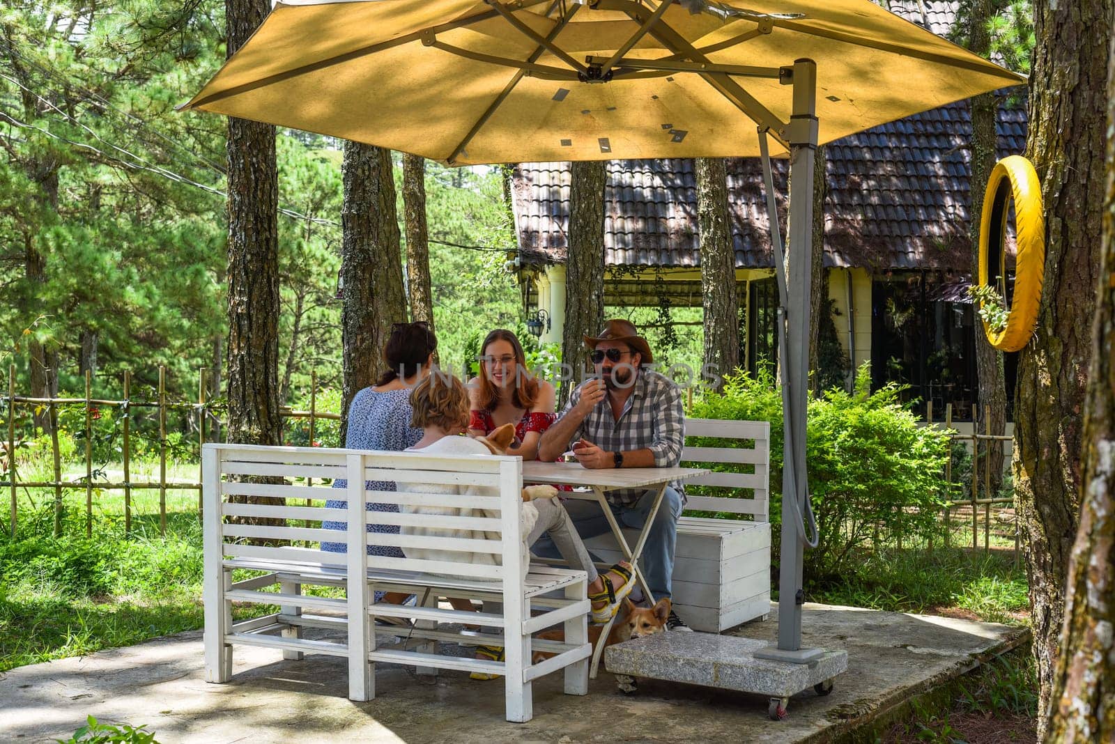 Family members father, mother and two daughters sit in alcove in park