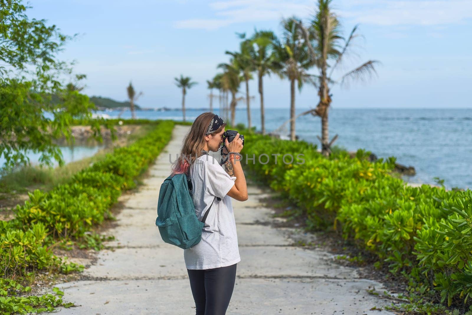 Cute  photographer and  travel blogger taking a photo with camera in summer