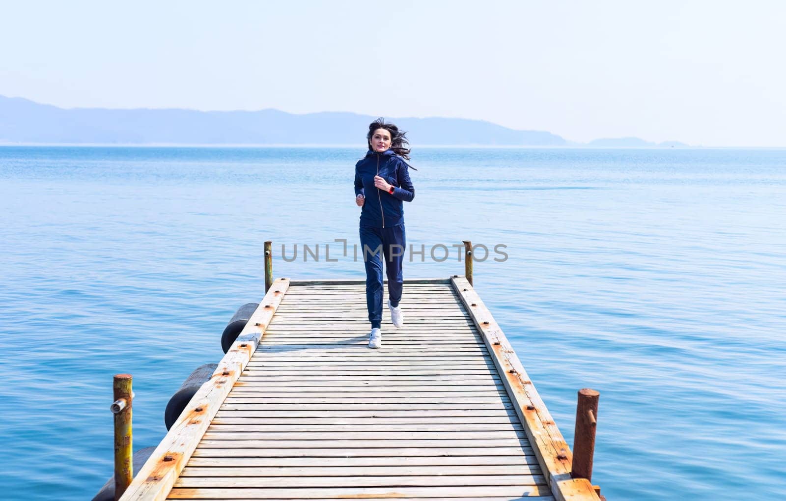 45 y.o. Russian woman running on a wooden pier by the Japanese sea