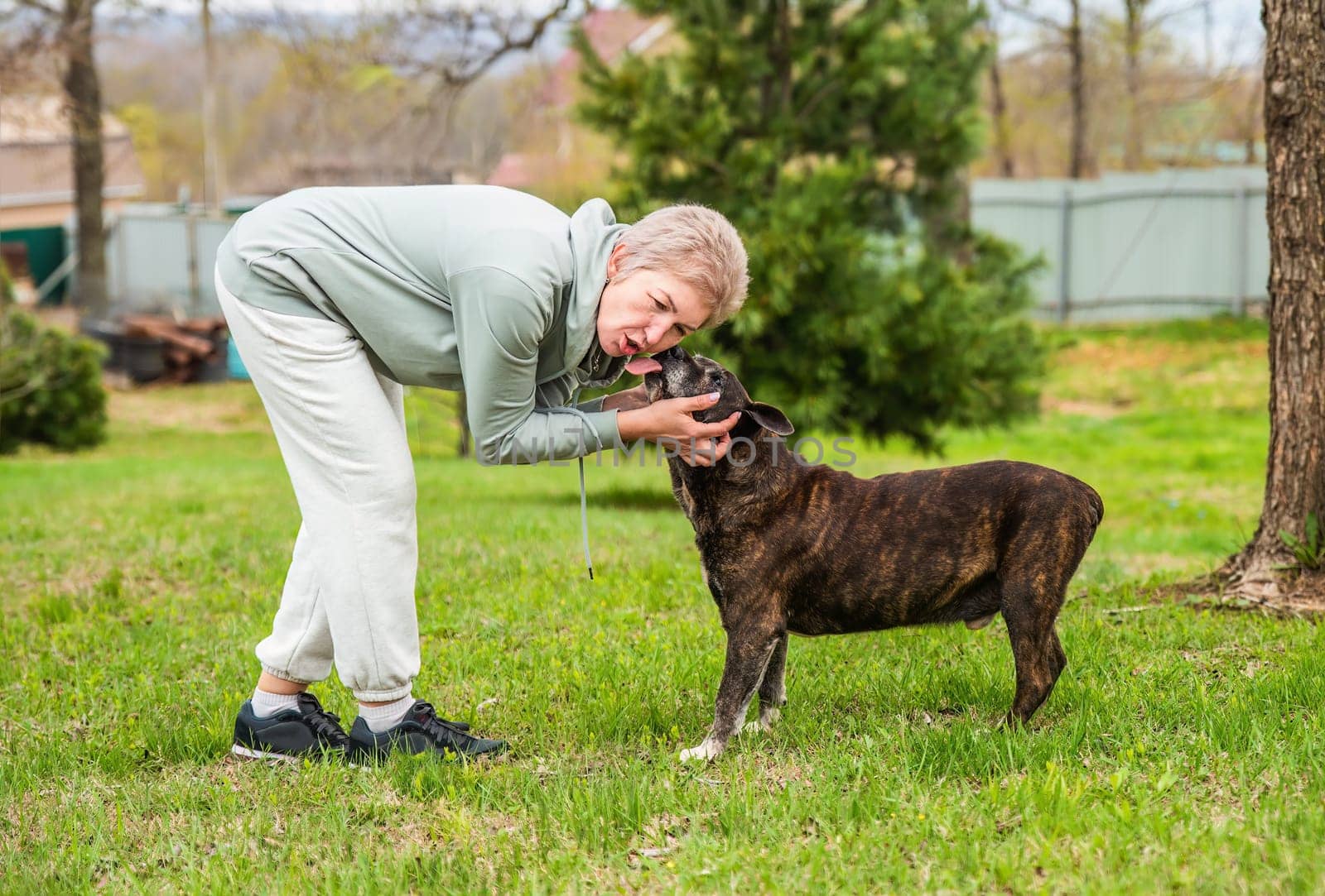 Mature woman playing with her dog outdoors