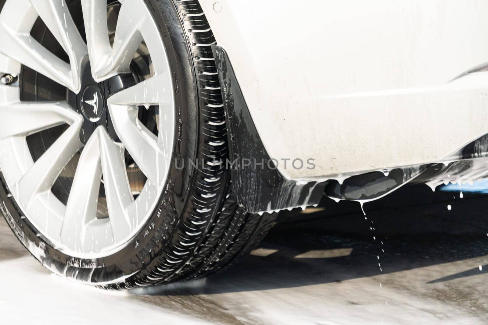 Denver, Colorado, USA-September 1, 2023-Efficiently cleaning an electric car in the comfort of a suburban driveway, combining eco-consciousness with practicality.