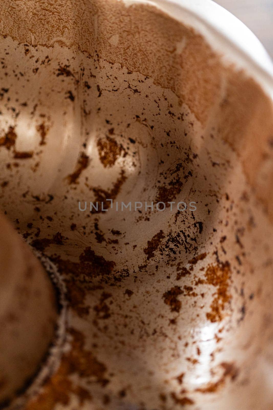 A close-up view of a dirty bundt cake pan after baking.