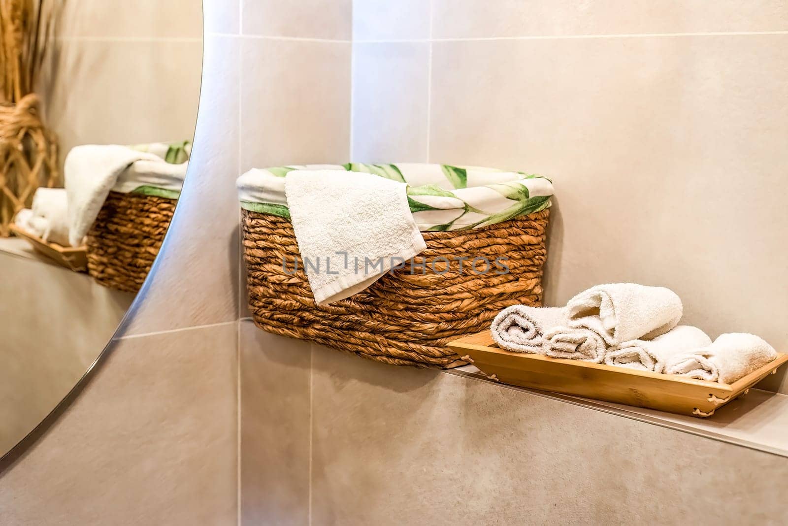 wooden wicker basket with towels on wooden shelf for bathroom