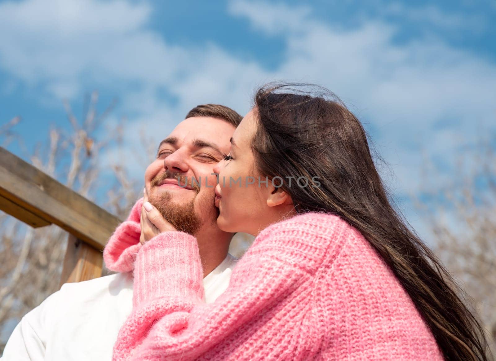 Romantic portrait of young married russian couple, woman kissing her husband