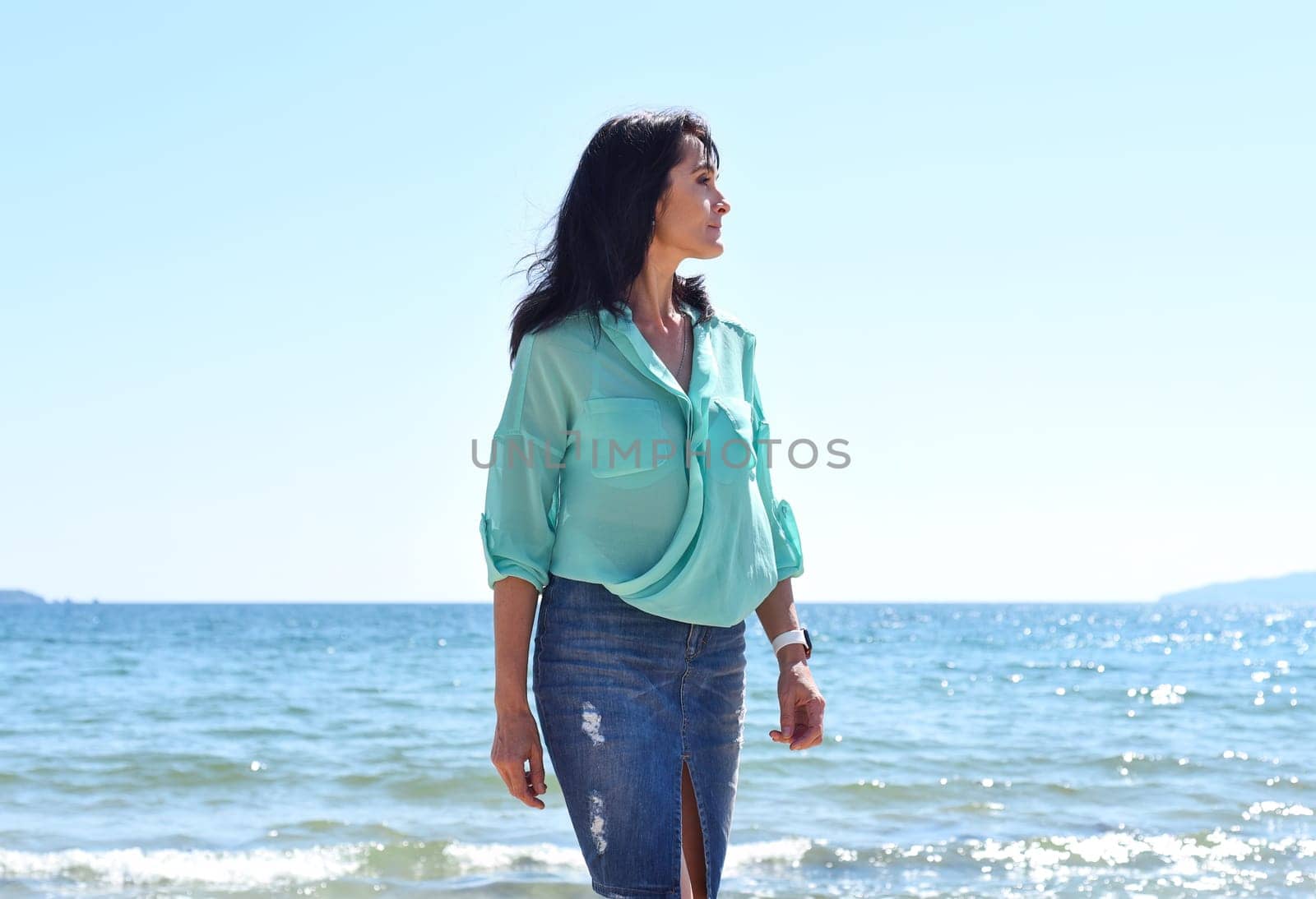 45 years old Russian woman standing in Japanese sea and looking away
