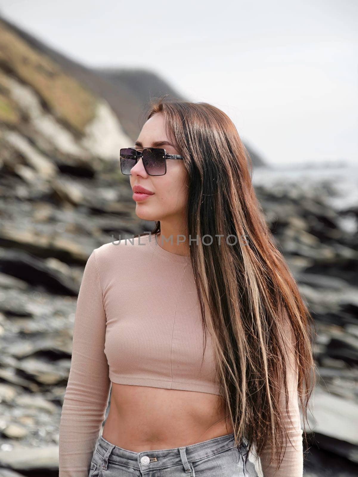 Young russian brunette woman in beige blouse standing near Japanese sea
