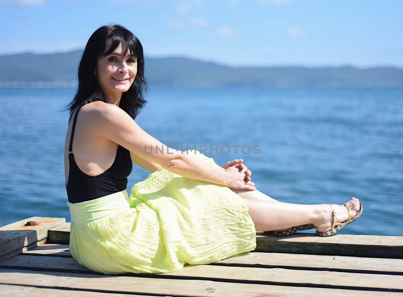 45 years old Russian woman smiling and looking at front against Japanese sea