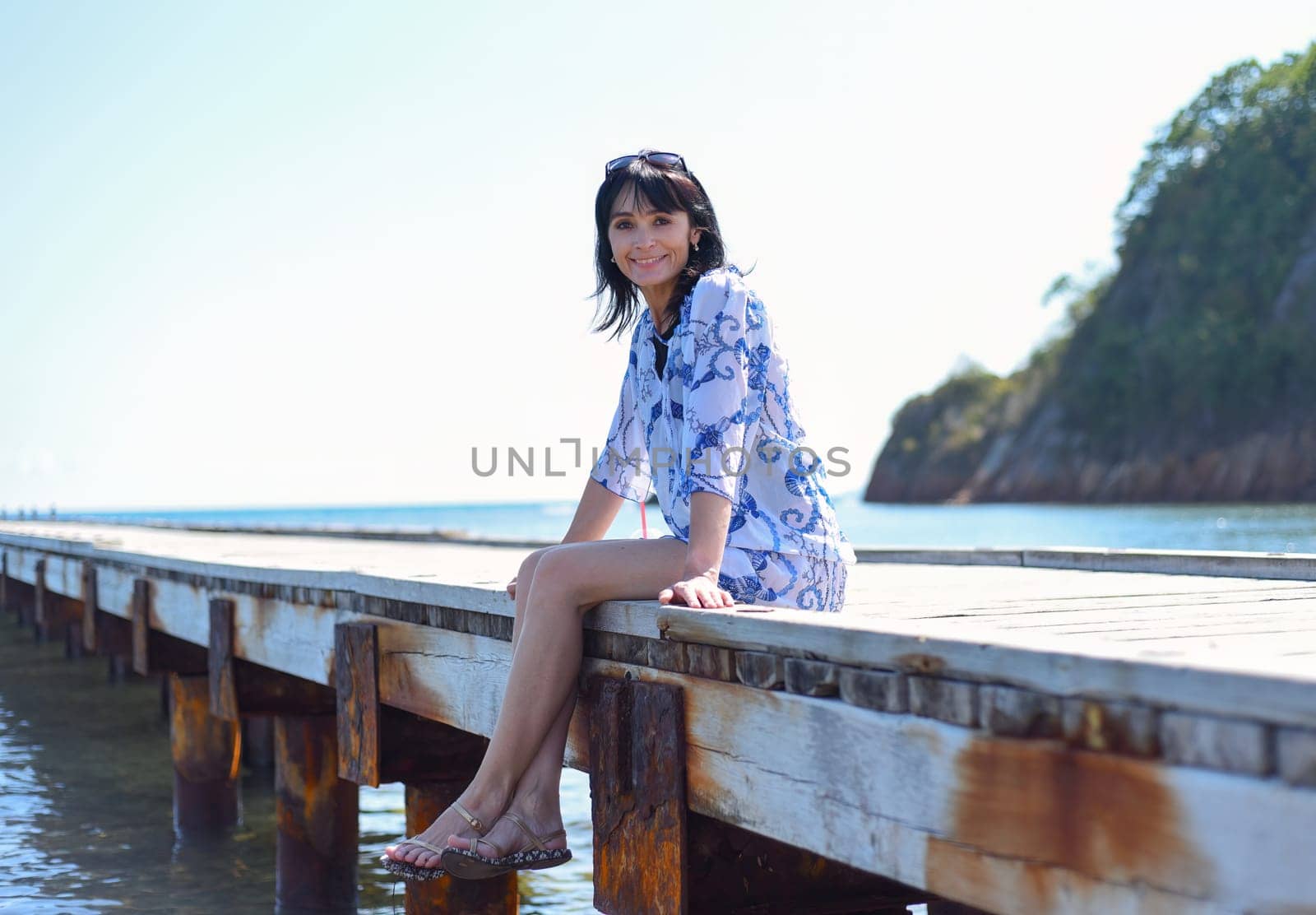 45 years old Russian woman smiling and looking at front against Japanese sea