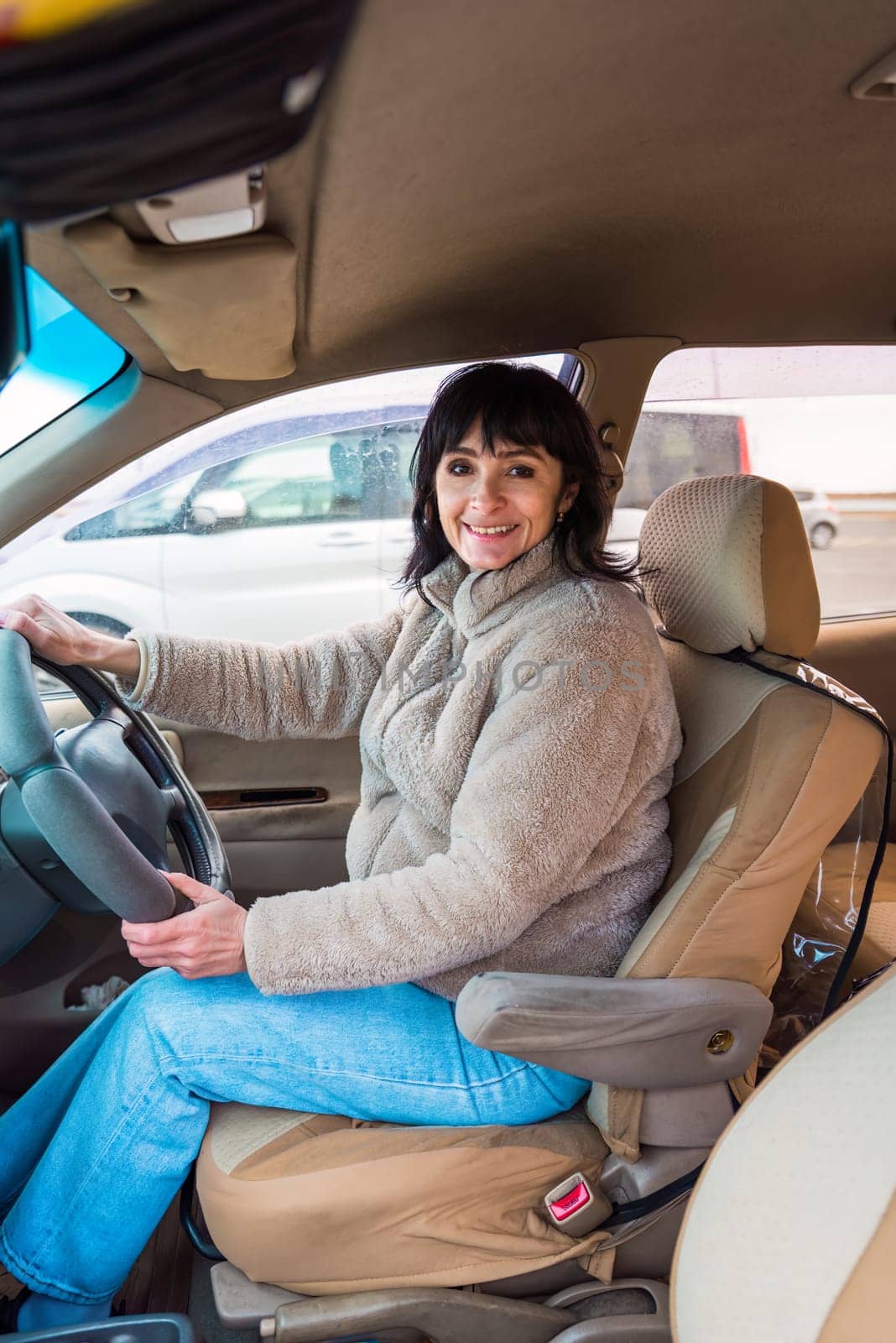 Young attractive 49 years old woman in jacket driving the car