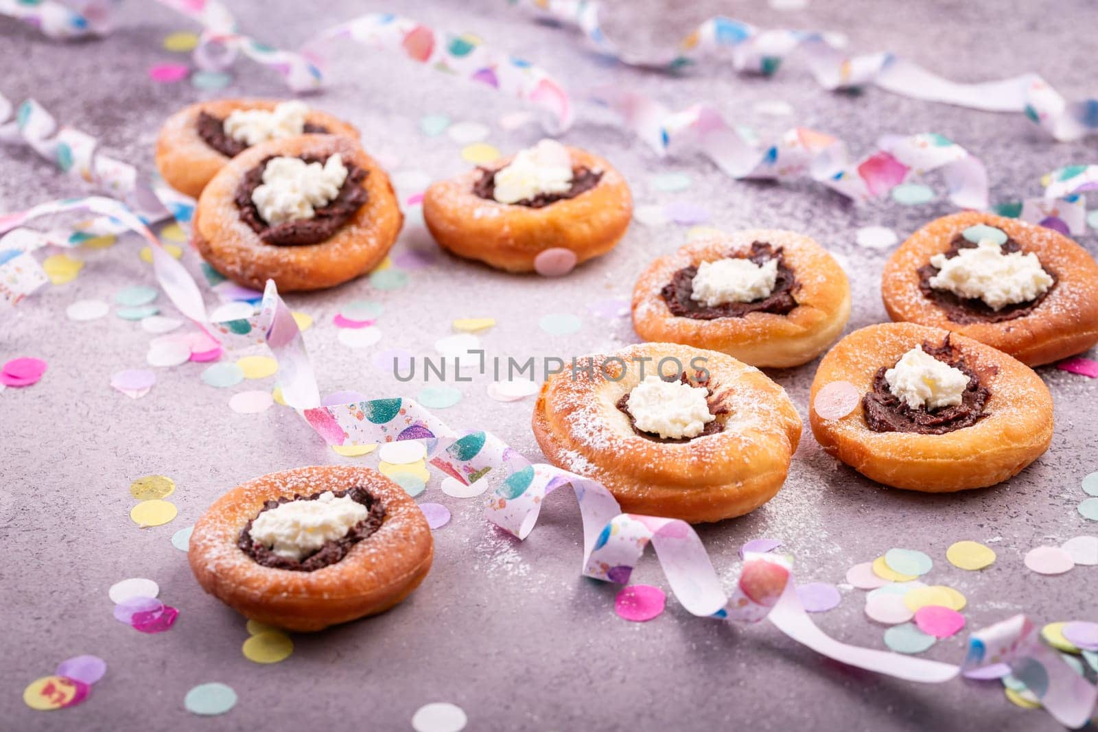 Carnival powdered sugar raised donuts with jelly and cream cheese, paper streamers and confetti