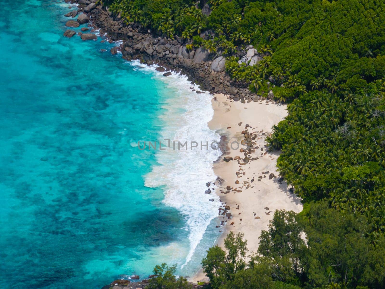 An unspoilt sandy beach in the middle of a rainforest. Seychelles, Mahe. Anse Capucins beach.