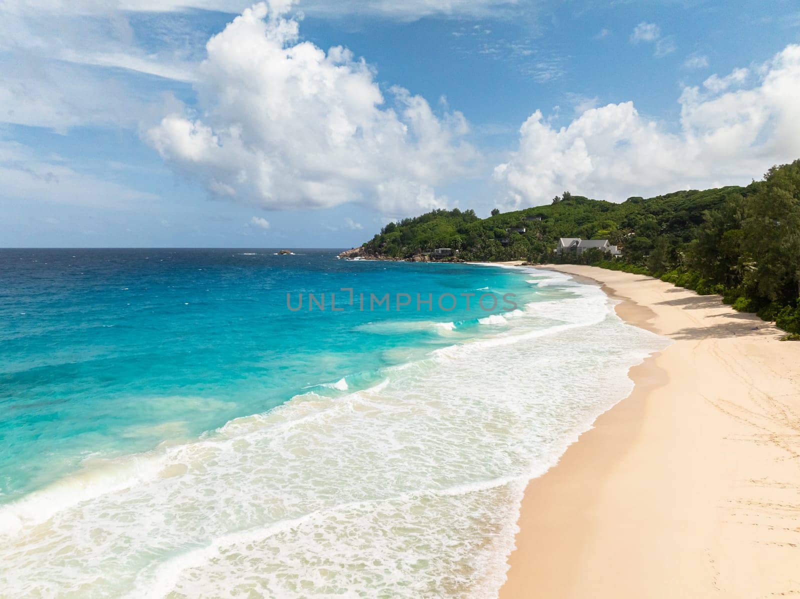This beach features soft, beige sand that slopes gently into the azure waters of the bay. Seychelles, Mahe. Anse Intendance beach.