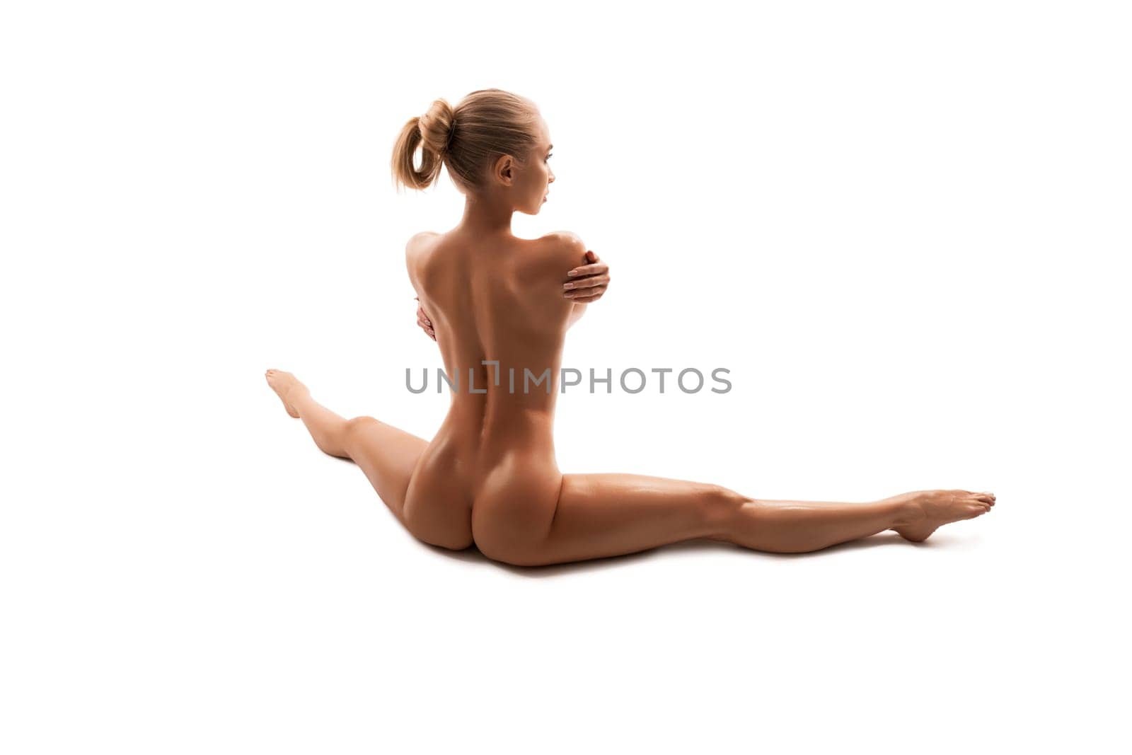 Naked blonde sitting on the floor isolated rearview