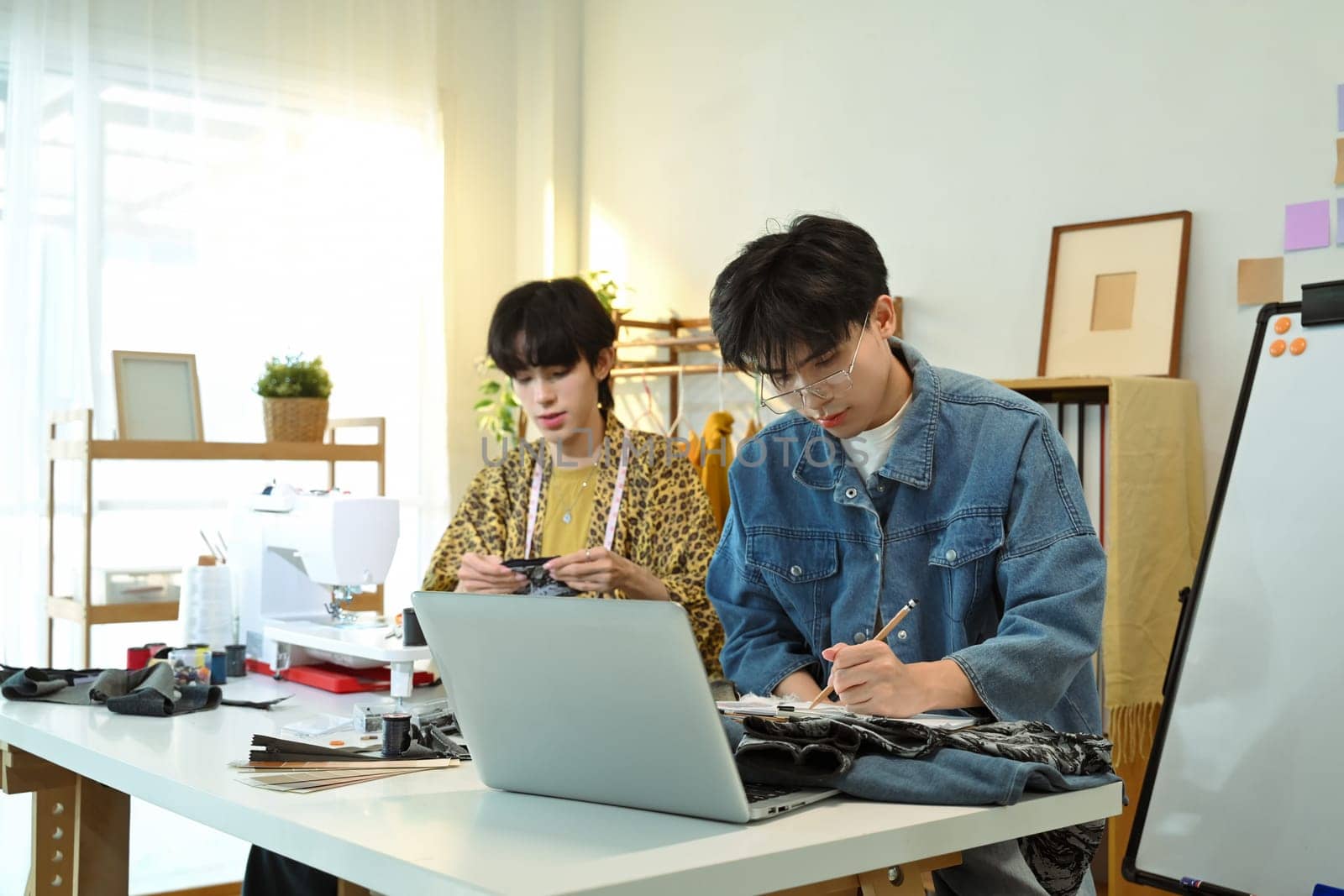 Skilled fashion designers brainstorming and constructing unique outfits in their studio.