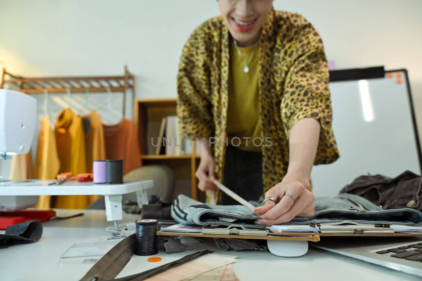 Stylish tailor working on a new garment design in a fashion studio.