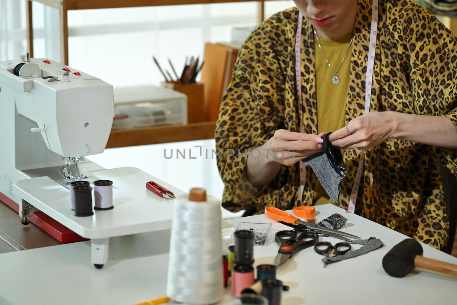 Cropped shot of stylish designer working on fabric sample in a fashion studio.